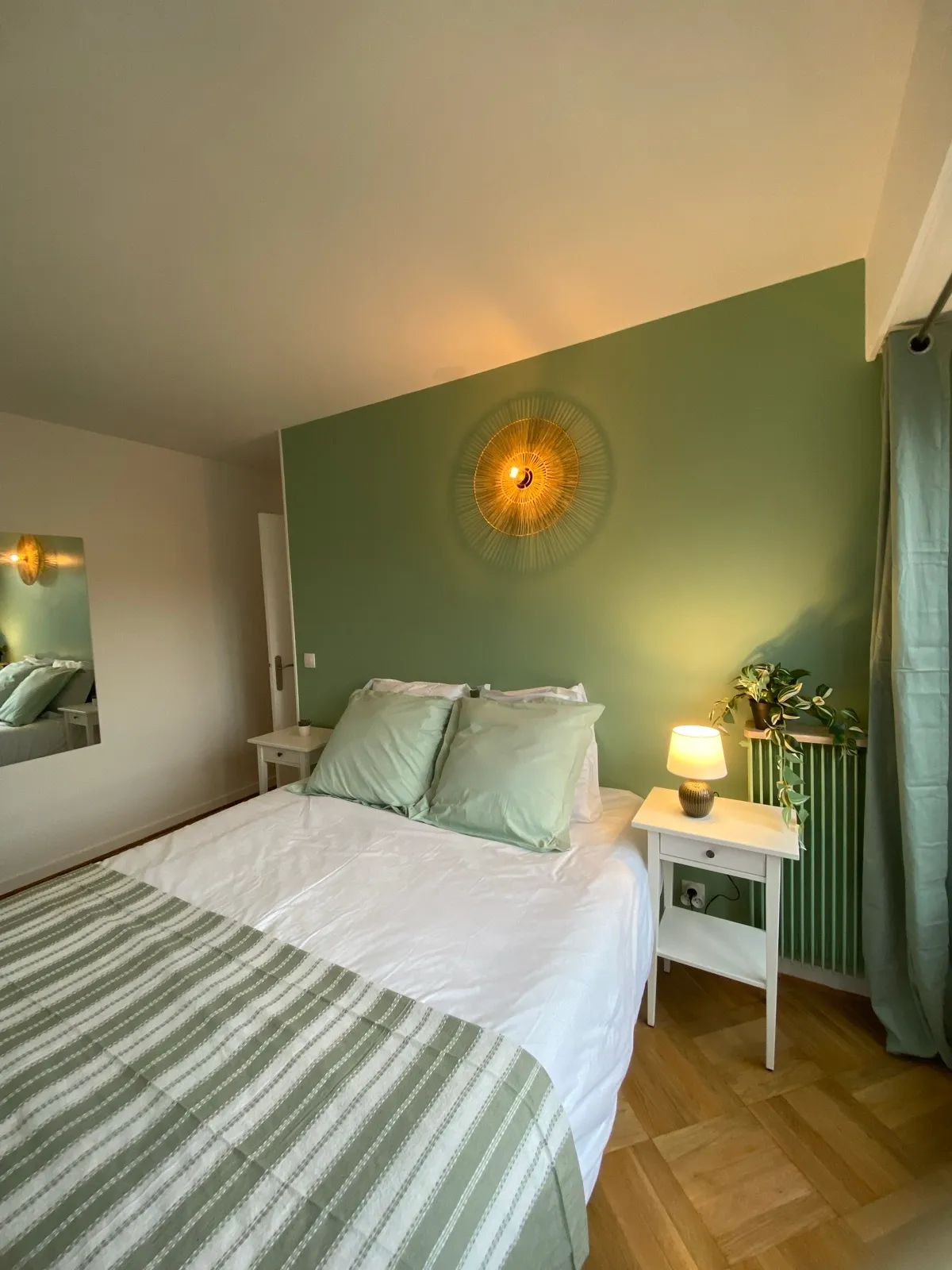 Chambre sauge, tête de lit en bois et miroir en rotin
